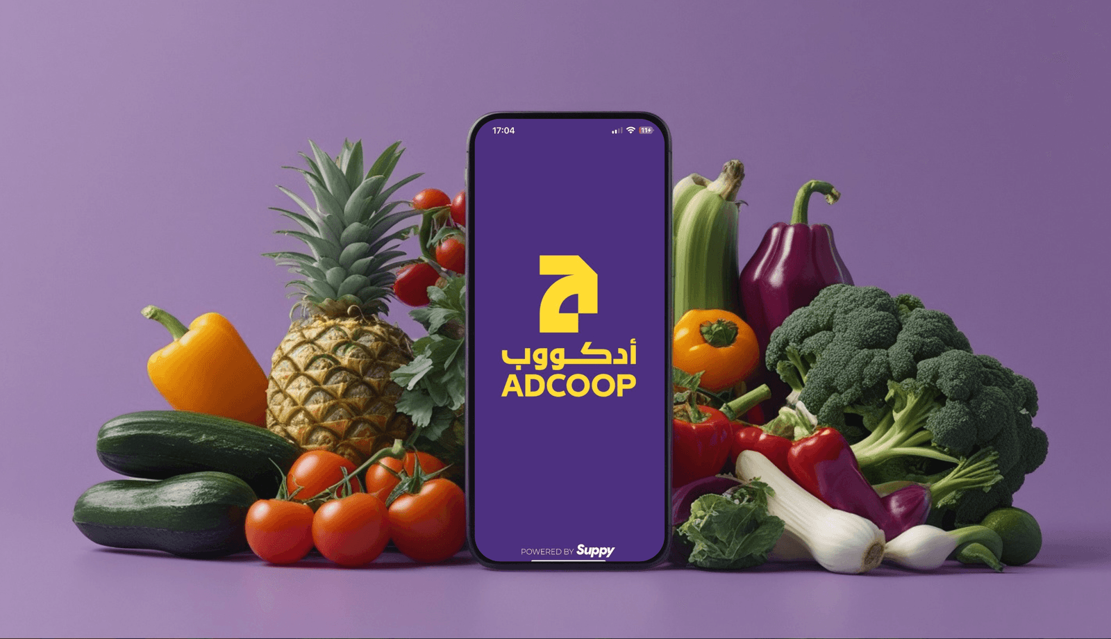 The ADCOOP app splash screen, powered by Suppy, on a phone surrounded by fresh produce.